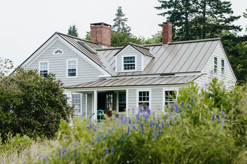 white colonial residential home with greenery