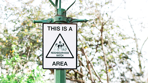 neighborhood watch signage on green metal pole